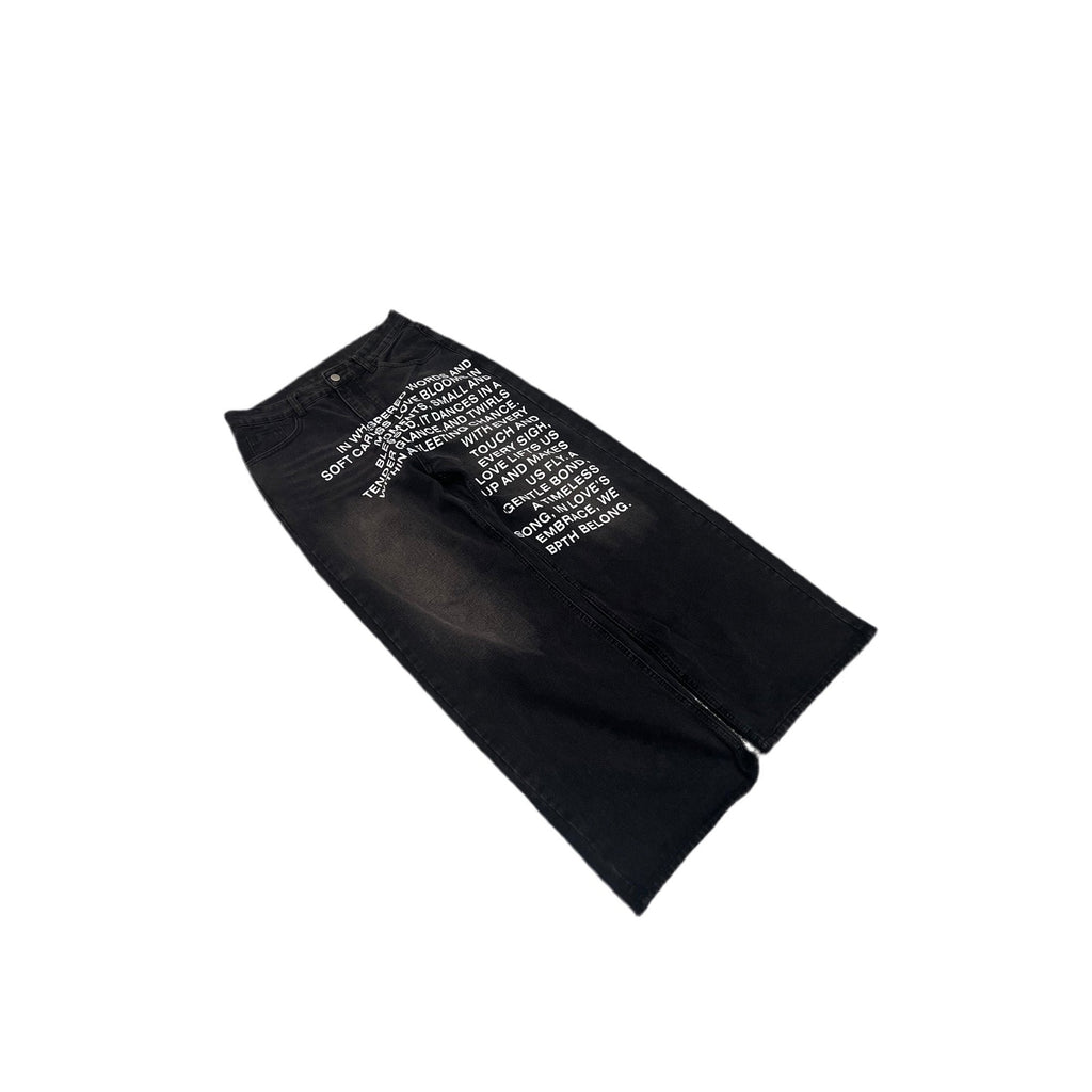 Black denim jeans with white text graphics printed on the front, displayed diagonally on a white background.