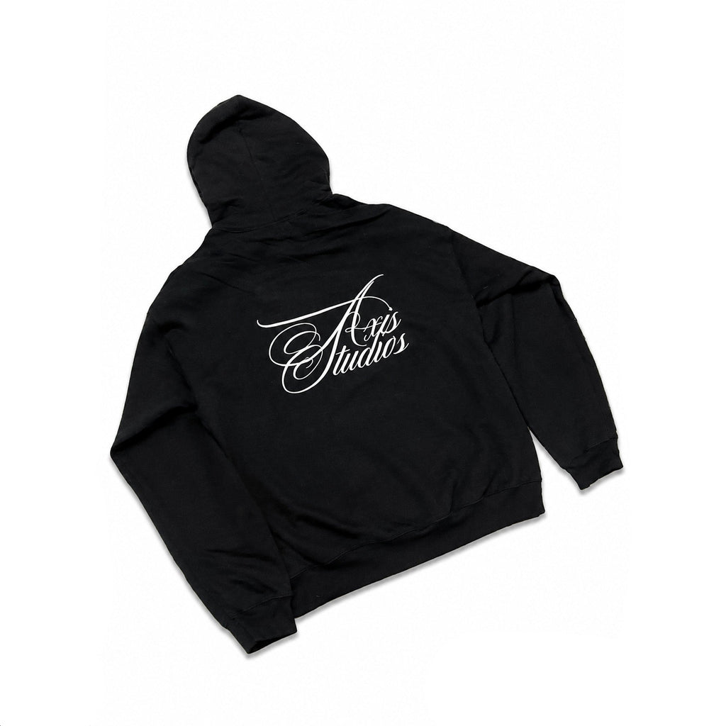 A black pullover hoodie shown from the back, featuring a white cursive 'Axis Studios' logo printed across the upper back. The hoodie is laid flat against a white background with black letterbox bars on the left and right, and a smaller 'AVS' logo watermark in the bottom right corner.