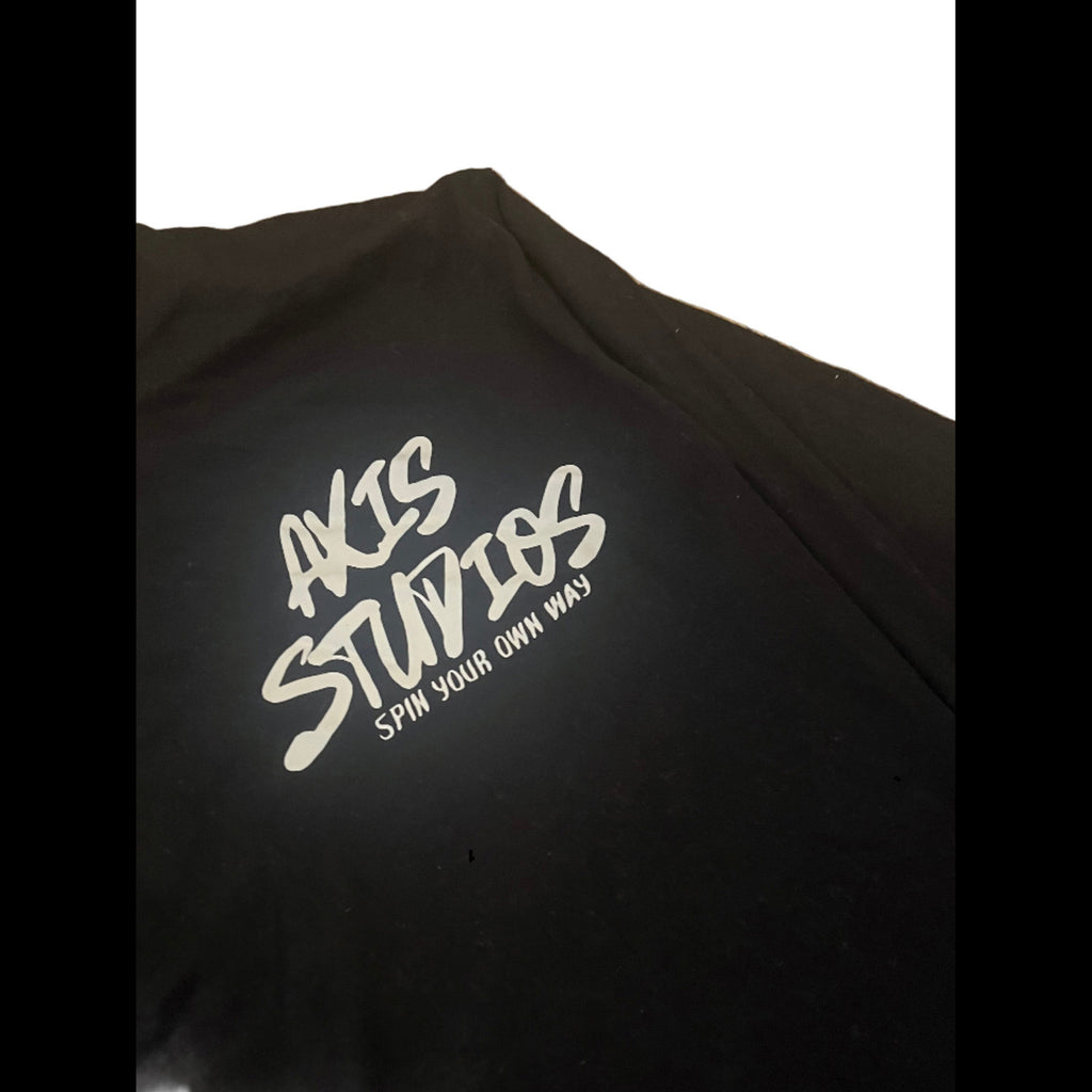 A close-up of a black t-shirt featuring a white graphic print that reads 'AXIS STUDIOS' and 'SPIN YOUR OWN WAY!' on the chest.