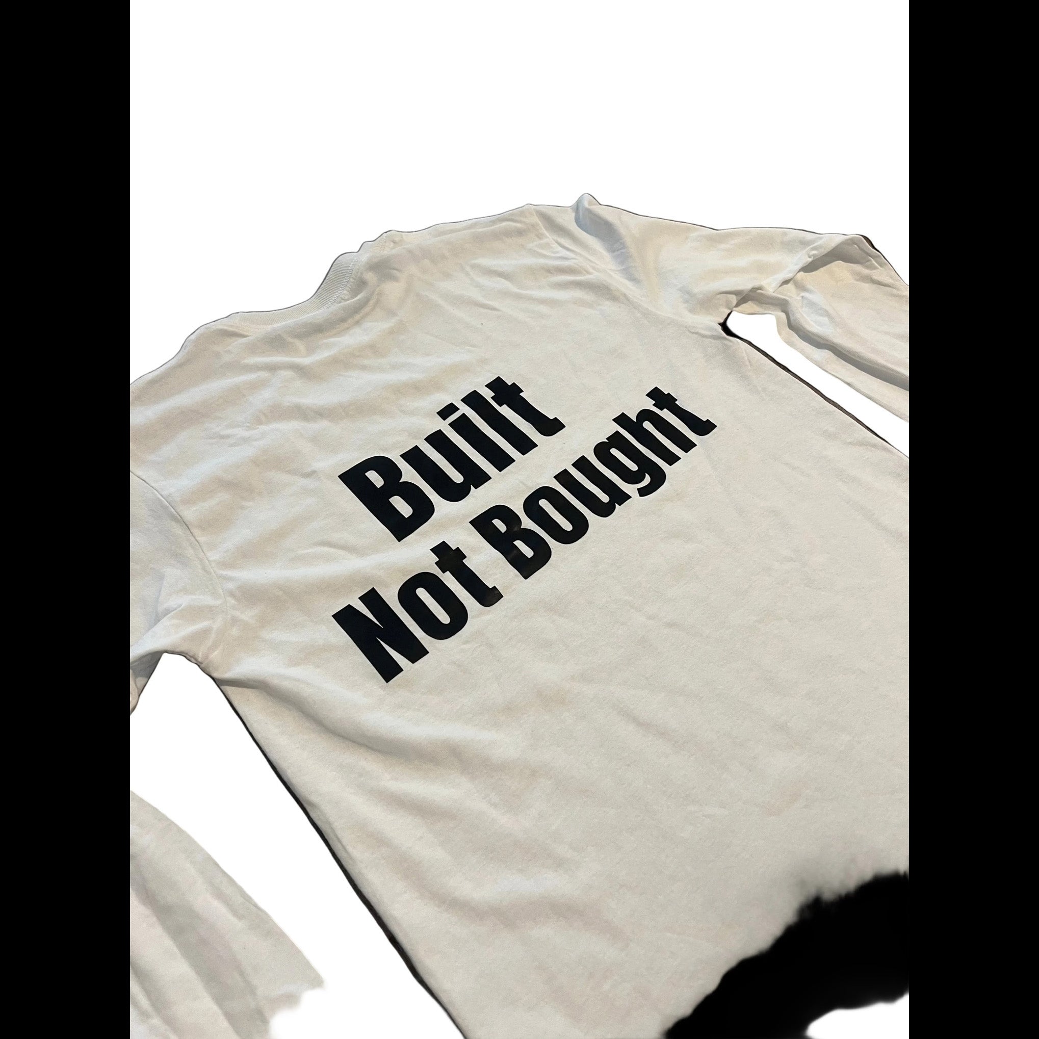 A white long-sleeve t-shirt with the phrase 'Built Not Bought' printed in bold black text across the chest, shown against a plain white background.